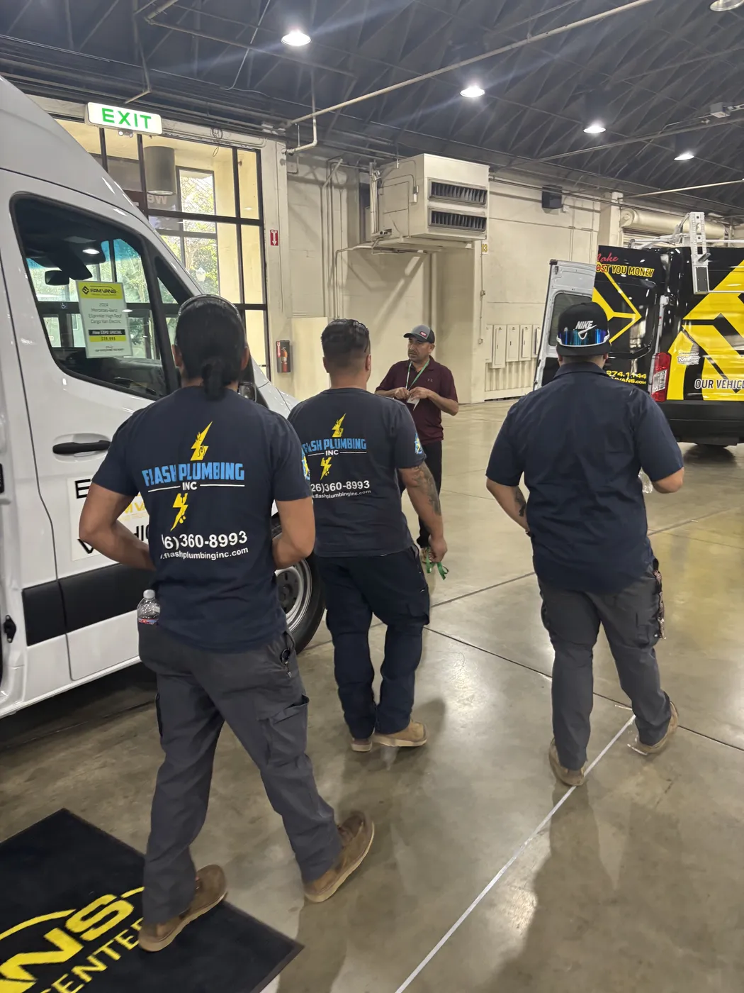 Flash Plumbing crew members walking together near their service van
