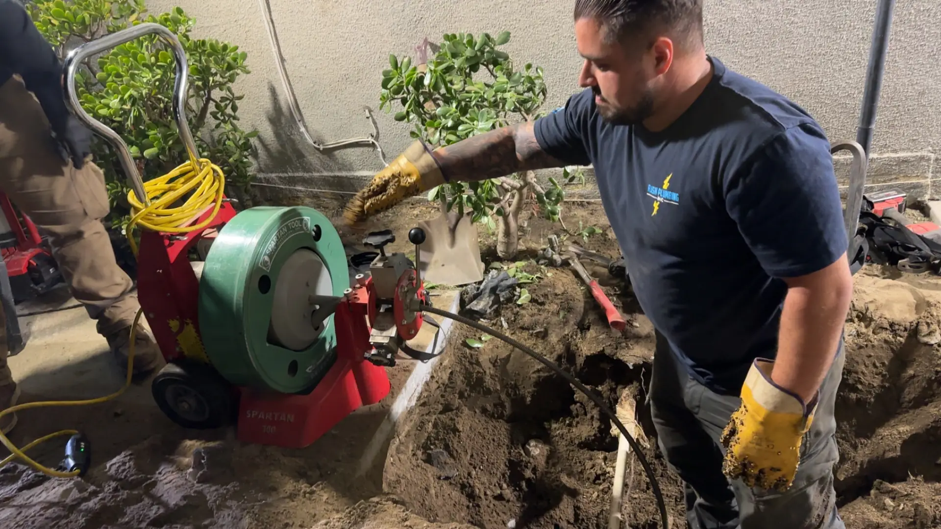 Flash Plumbing technician running a drain cleaning machine into a cleanout