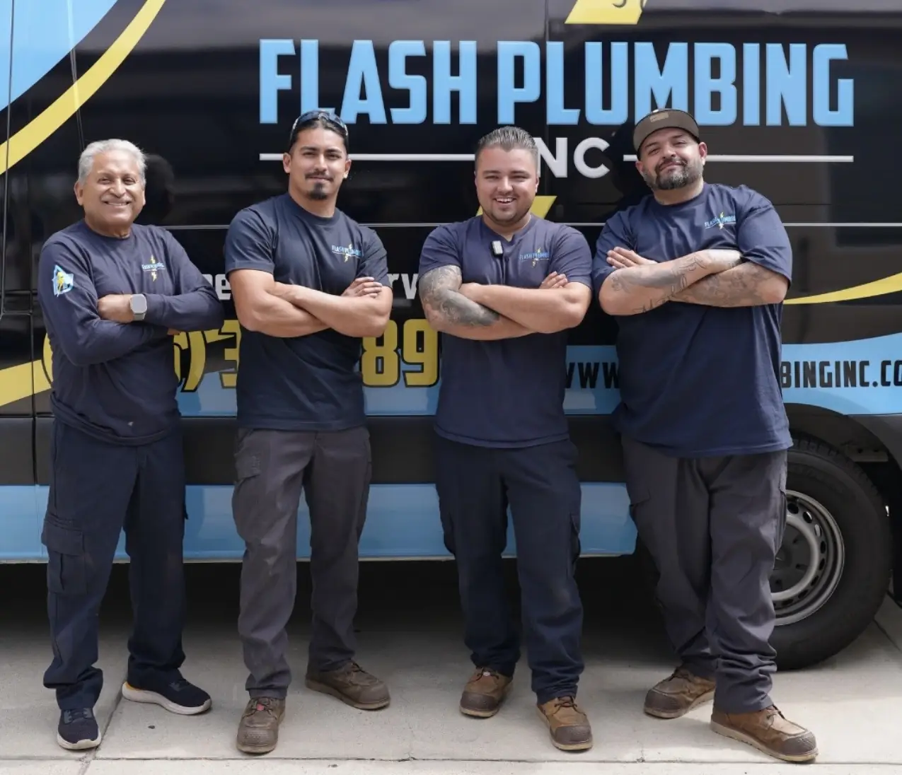Four Flash Plumbing team members standing with arms crossed in front of a Flash Plumbing van