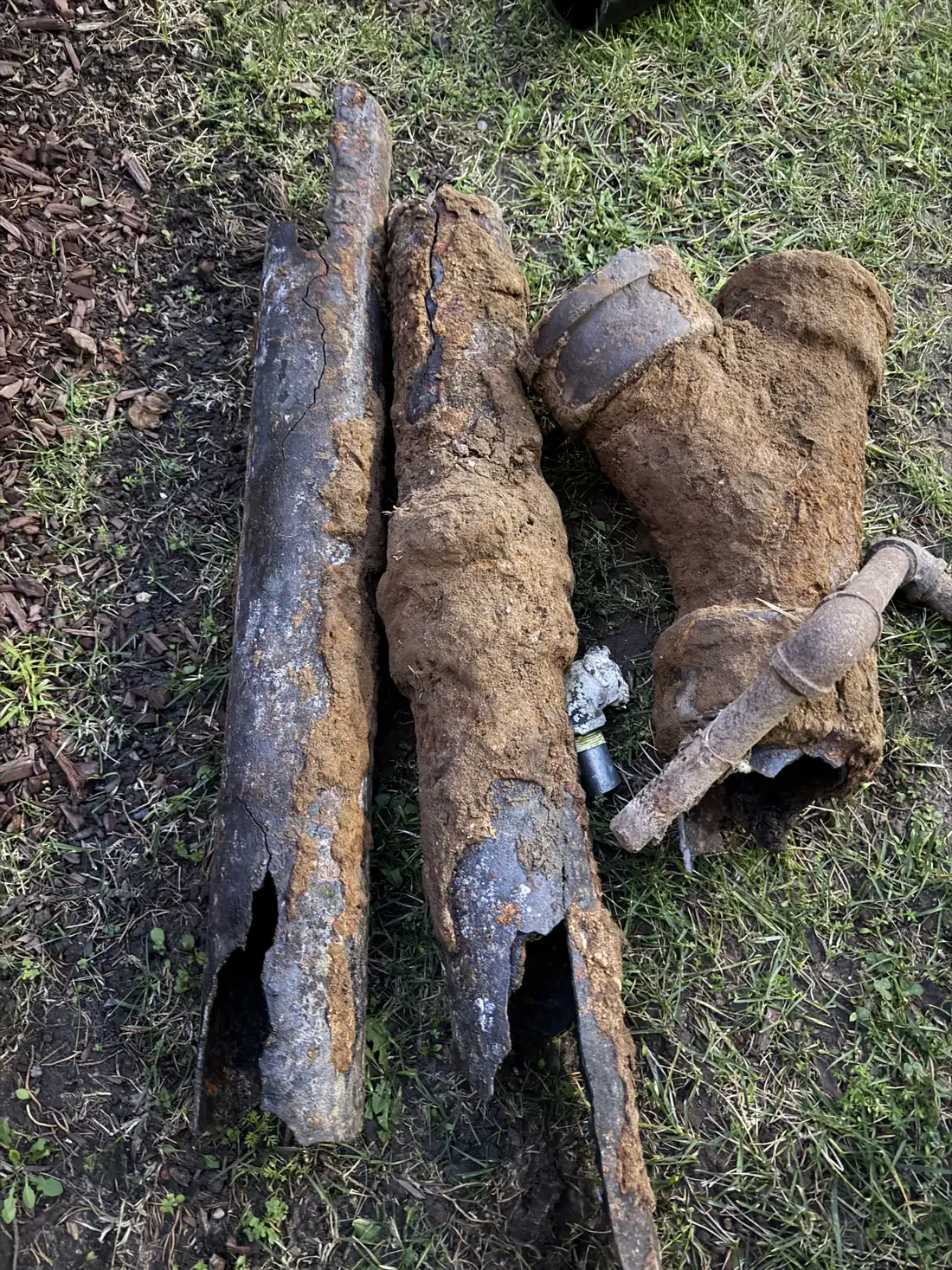 Corroded sections of old cast iron sewer pipe removed from a yard