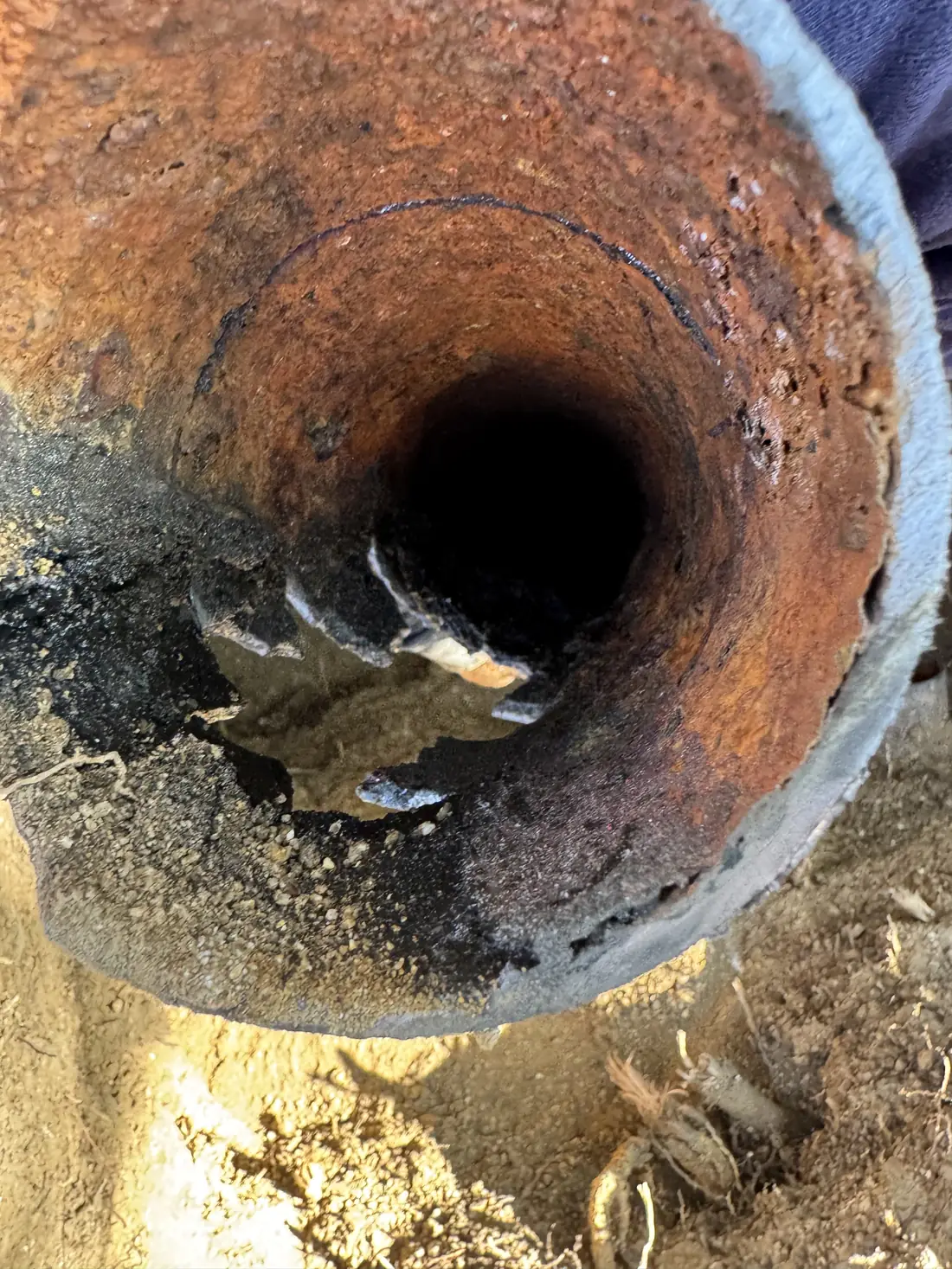 Inside of an old drain pipe narrowed by rust and scale
