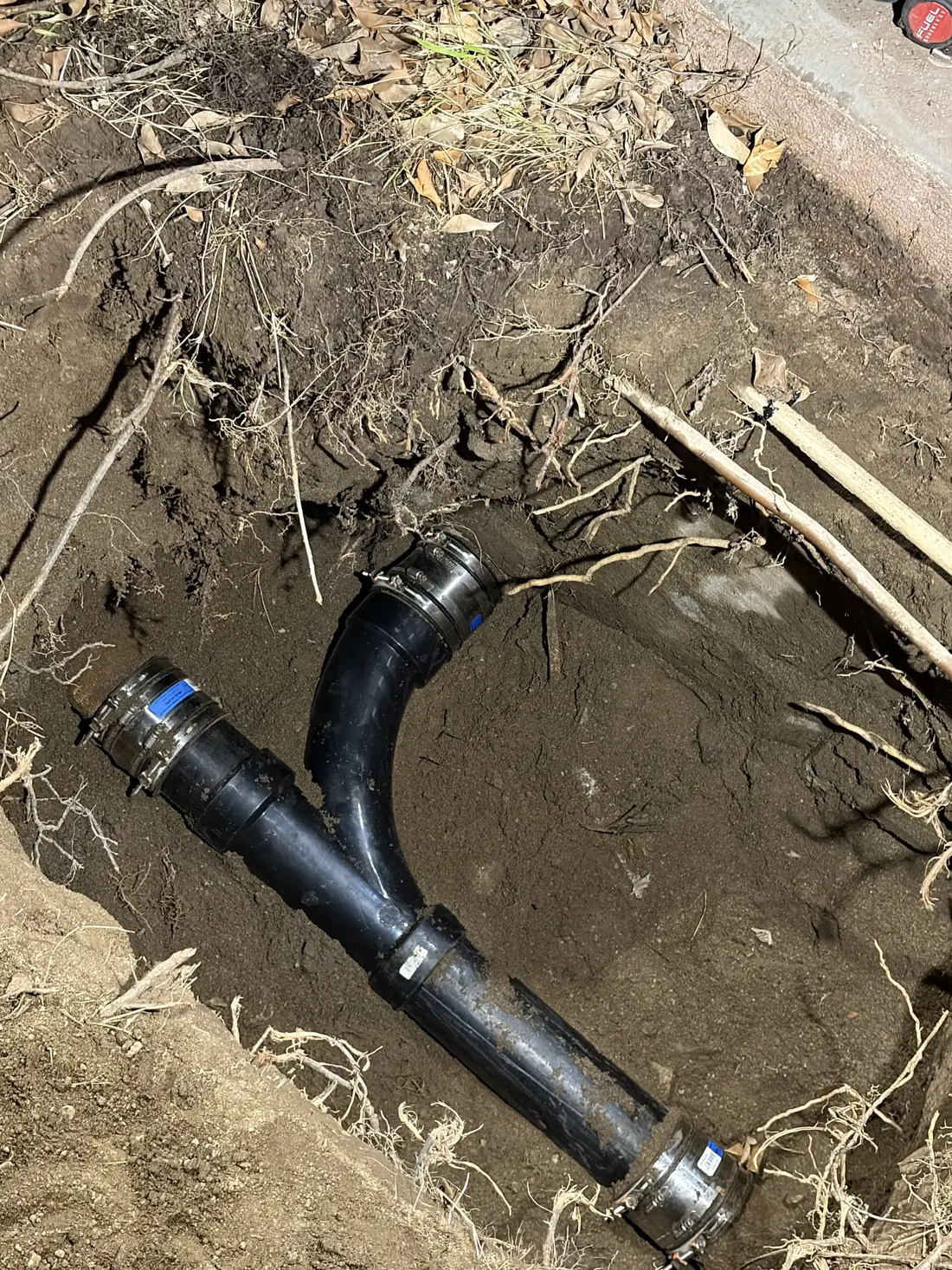 Replaced sewer wye fitting with new couplings in a trench