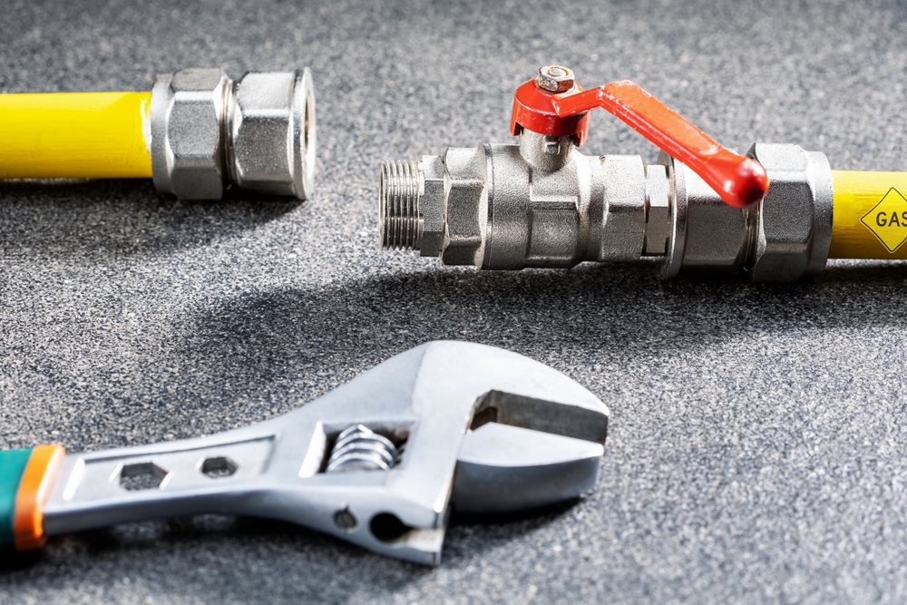Gas,Pipe,Line,,Valve,And,Wrench,On,Gray,Surface.
